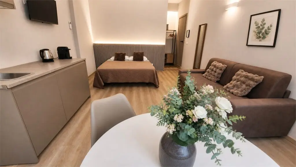 Room 3 di Gaia Suites Torino con letto, divano letto, zona pranzo e angolo ristoro